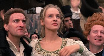 Movie still from “The Adventures of Baron Munchausen” (1988), directed by Terry Gilliam – A woman in a dress is standing in front of a group of people; Close Up shot, Low angle