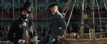 Movie still from “The Aeronauts” (2019), directed by Tom Harper – A man sitting on top of a boat in front of an audience; Medium shot, Low angle