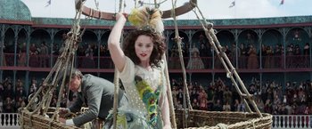 Movie still from “The Aeronauts” (2019), directed by Tom Harper – A woman in a fancy costume is standing in a crowd; Medium shot, Over the shoulder angle