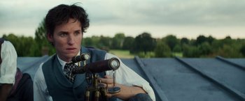 Movie still from “The Aeronauts” (2019), directed by Tom Harper – A woman sitting on top of a building looking through a telescope; Close Up shot, Low angle