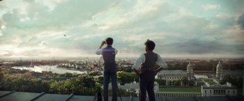 Movie still from “The Aeronauts” (2019), directed by Tom Harper – Two men standing on the edge of a building looking out over a city; Extreme Wide shot, Over the shoulder angle