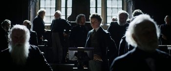 Movie still from “The Aeronauts” (2019), directed by Tom Harper – A man standing in front of a group of people; Medium shot, Low angle