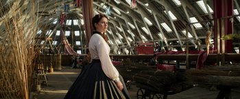 Movie still from “The Aeronauts” (2019), directed by Tom Harper – A woman in a long skirt standing next to a wagon; Medium shot, Low angle