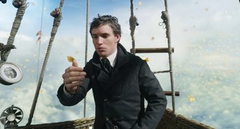 Movie still from “The Aeronauts” (2019), directed by Tom Harper – A man in a black jacket holding a piece of fruit; Close Up shot, Low angle