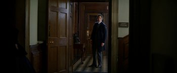 Movie still from “The Aeronauts” (2019), directed by Tom Harper – A man standing in a room with a door open; Wide shot, Low angle