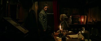Movie still from “The Aeronauts” (2019), directed by Tom Harper – A man and a woman standing in front of a table; Medium shot, Over the shoulder angle