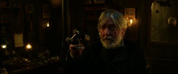 Movie still from “The Aeronauts” (2019), directed by Tom Harper – An older man holding a pair of binoculars in his hand; Close Up shot, Over the shoulder angle
