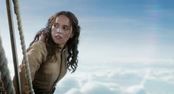 Movie still from “The Aeronauts” (2019), directed by Tom Harper – A woman with long brown curly hair standing on top of a cloud covered sky; Close Up shot, Low angle
