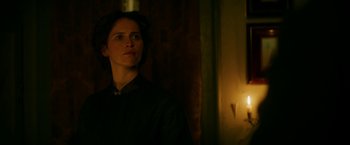 Movie still from “The Aeronauts” (2019), directed by Tom Harper – A woman standing in front of a window in a dark room; Close Up shot, Low angle