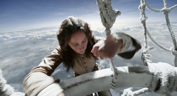 Movie still from “The Aeronauts” (2019), directed by Tom Harper – A woman holding onto a rope while standing on a ledge; Medium shot, Overhead angle