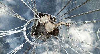 Movie still from “The Aeronauts” (2019), directed by Tom Harper – A man hanging upside down in a ferris wheel; Wide shot, Overhead angle