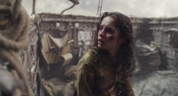 Movie still from “The Aeronauts” (2019), directed by Tom Harper – A woman in a brown jacket is standing in front of a wooden structure; Close Up shot, Over the shoulder angle
