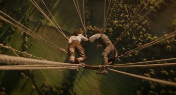 Movie still from “The Aeronauts” (2019), directed by Tom Harper – Two skateboarders are hanging on a rope bridge; Wide shot, Overhead angle