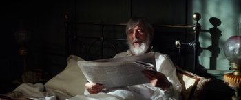 Movie still from “The Aeronauts” (2019), directed by Tom Harper – An older man sitting in a bed reading a newspaper; Medium shot, High angle