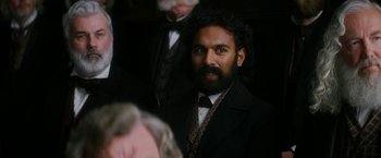 Movie still from “The Aeronauts” (2019), directed by Tom Harper – A man in a suit and tie standing next to another man in a suit and tie; Close Up shot, Over the shoulder angle