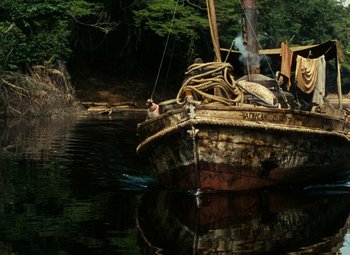Movie still from “The African Queen” (1951), directed by John Huston – An old wooden boat in a body of water; Extreme Wide shot, High angle