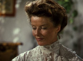 Movie still from “The African Queen” (1951), directed by John Huston – An older woman wearing a white dress with a floral pattern; Close Up shot, Over the shoulder angle
