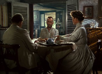 Movie still from “The African Queen” (1951), directed by John Huston – A group of people sitting around a table; Wide shot, High angle