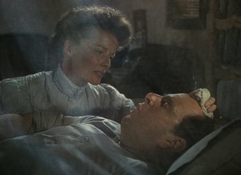 Movie still from “The African Queen” (1951), directed by John Huston – An older woman touching the forehead of an older man in bed; Close Up shot, Overhead angle