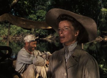 Movie still from “The African Queen” (1951), directed by John Huston – An older woman wearing a large hat and a man wearing a hat; Medium shot, Low angle