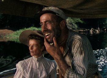 Movie still from “The African Queen” (1951), directed by John Huston – A man and a woman sitting next to each other on a boat; Close Up shot, Low angle