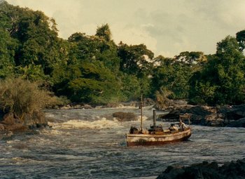 Movie still from “The African Queen” (1951), directed by John Huston – An old boat is in the middle of a river; Extreme Wide shot, High angle