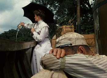 Movie still from “The African Queen” (1951), directed by John Huston – An old man and a woman with an umbrella; Medium shot, Low angle