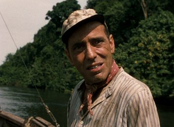 Movie still from “The African Queen” (1951), directed by John Huston – A person wearing a hat near a body of water; Close Up shot, Over the shoulder angle