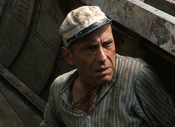 Movie still from “The African Queen” (1951), directed by John Huston – A man wearing a hat and a striped shirt; Close Up shot, High angle