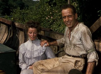 Movie still from “The African Queen” (1951), directed by John Huston – A man and a woman sitting on a wooden bench; Medium shot, Low angle