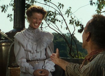 Movie still from “The African Queen” (1951), directed by John Huston – An older man and a woman are talking outside; Medium shot, Over the shoulder angle