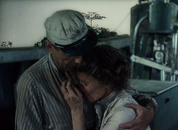 Movie still from “The African Queen” (1951), directed by John Huston – An older man and a younger woman hugging; Medium shot, High angle