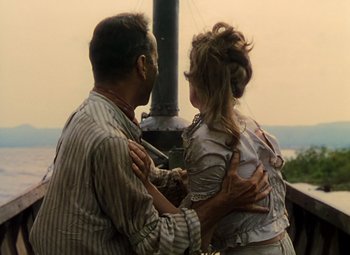 Movie still from “The African Queen” (1951), directed by John Huston – A man and a woman are hugging outside; Medium shot, Over the shoulder angle
