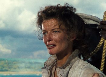 Movie still from “The African Queen” (1951), directed by John Huston – An older woman with curly brown hair wearing a white shirt; Close Up shot, Low angle