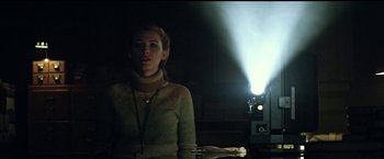 Movie still from “The Age of Adaline” (2015), directed by Lee Toland Krieger – A woman is standing in front of a movie projector; Medium shot, Low angle
