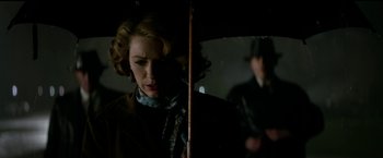 Movie still from “The Age of Adaline” (2015), directed by Lee Toland Krieger – A woman holding an open umbrella in a dark room; Medium shot, Low angle