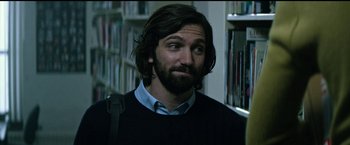 Movie still from “The Age of Adaline” (2015), directed by Lee Toland Krieger – A man with long hair and a beard is standing in a library; Close Up shot, Over the shoulder angle