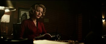 Movie still from “The Age of Adaline” (2015), directed by Lee Toland Krieger – A woman in a red dress sitting in front of a book; Medium shot, Low angle