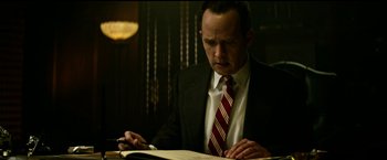 Movie still from “The Age of Adaline” (2015), directed by Lee Toland Krieger – A man in a suit and tie writing on a book; Medium shot, Low angle