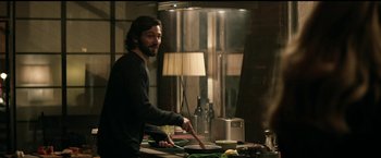 Movie still from “The Age of Adaline” (2015), directed by Lee Toland Krieger – A man standing at a table with a knife in his hand; Medium shot, Over the shoulder angle