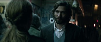 Movie still from “The Age of Adaline” (2015), directed by Lee Toland Krieger – A man with long hair and a beard standing next to another man; Close Up shot, Over the shoulder angle
