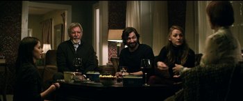 Movie still from “The Age of Adaline” (2015), directed by Lee Toland Krieger – A group of people sitting around a table with wine glasses; Medium shot, Over the shoulder angle