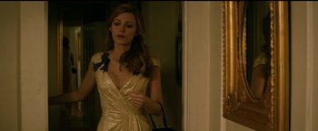 Movie still from “The Age of Adaline” (2015), directed by Lee Toland Krieger – A woman in a gold dress holding a purse; Medium shot, Over the shoulder angle