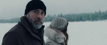 Movie still from “The American” (2010), directed by Anton Corbijn – A man and a woman standing next to each other in the snow; Close Up shot, Over the shoulder angle