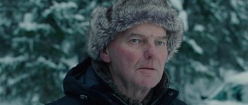Movie still from “The American” (2010), directed by Anton Corbijn – A person wearing a fur hat; Close Up shot, Over the shoulder angle