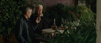 Movie still from “The American” (2010), directed by Anton Corbijn – A man and a woman sitting at a table drinking wine; Medium shot, Over the shoulder angle