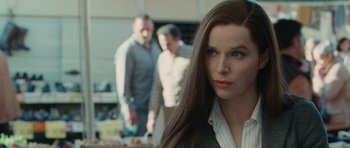 Movie still from “The American” (2010), directed by Anton Corbijn – A woman standing in front of two other men; Close Up shot, Over the shoulder angle