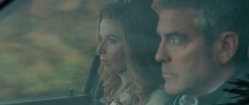 Movie still from “The American” (2010), directed by Anton Corbijn – A man and a woman sitting in a car looking out the window; Close Up shot, Low angle