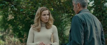 Movie still from “The American” (2010), directed by Anton Corbijn – A woman in a beige sweater talking to a man in a green shirt; Medium shot, Over the shoulder angle