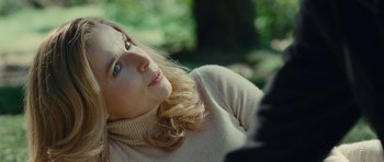 Movie still from “The American” (2010), directed by Anton Corbijn – A woman in a white sweater looking up at the sky; Close Up shot, Over the shoulder angle